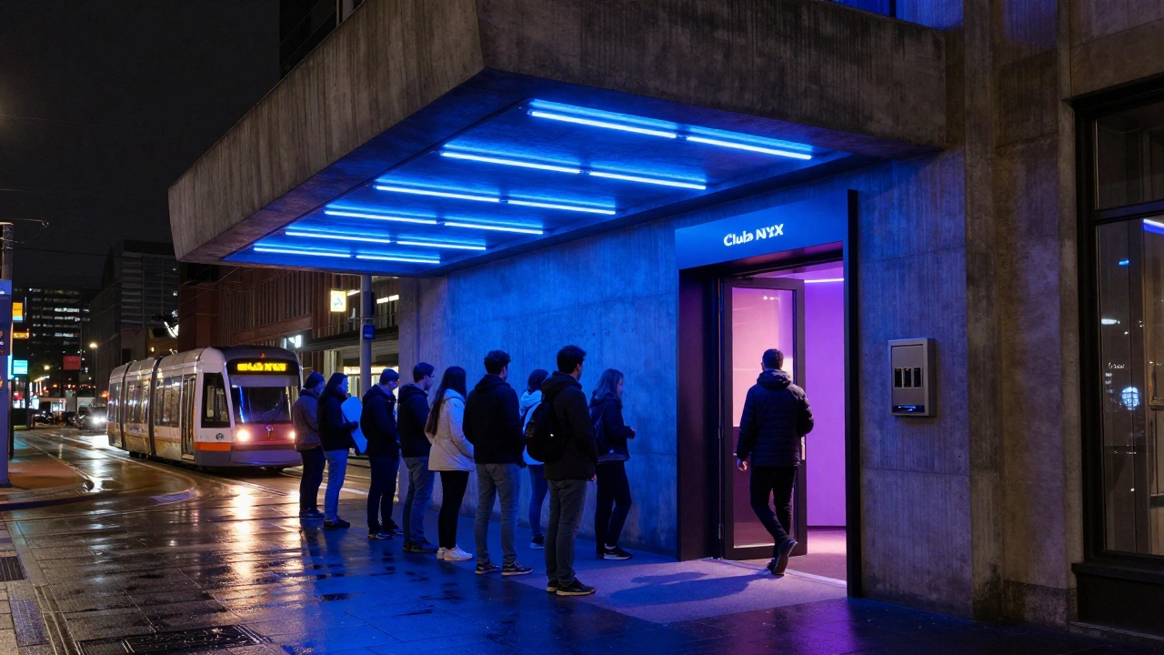 Iemand stapt binnen bij Club NYX bij openingsuur, met een tram in de verte en neonverlichting die de betonnen gevels verlicht.